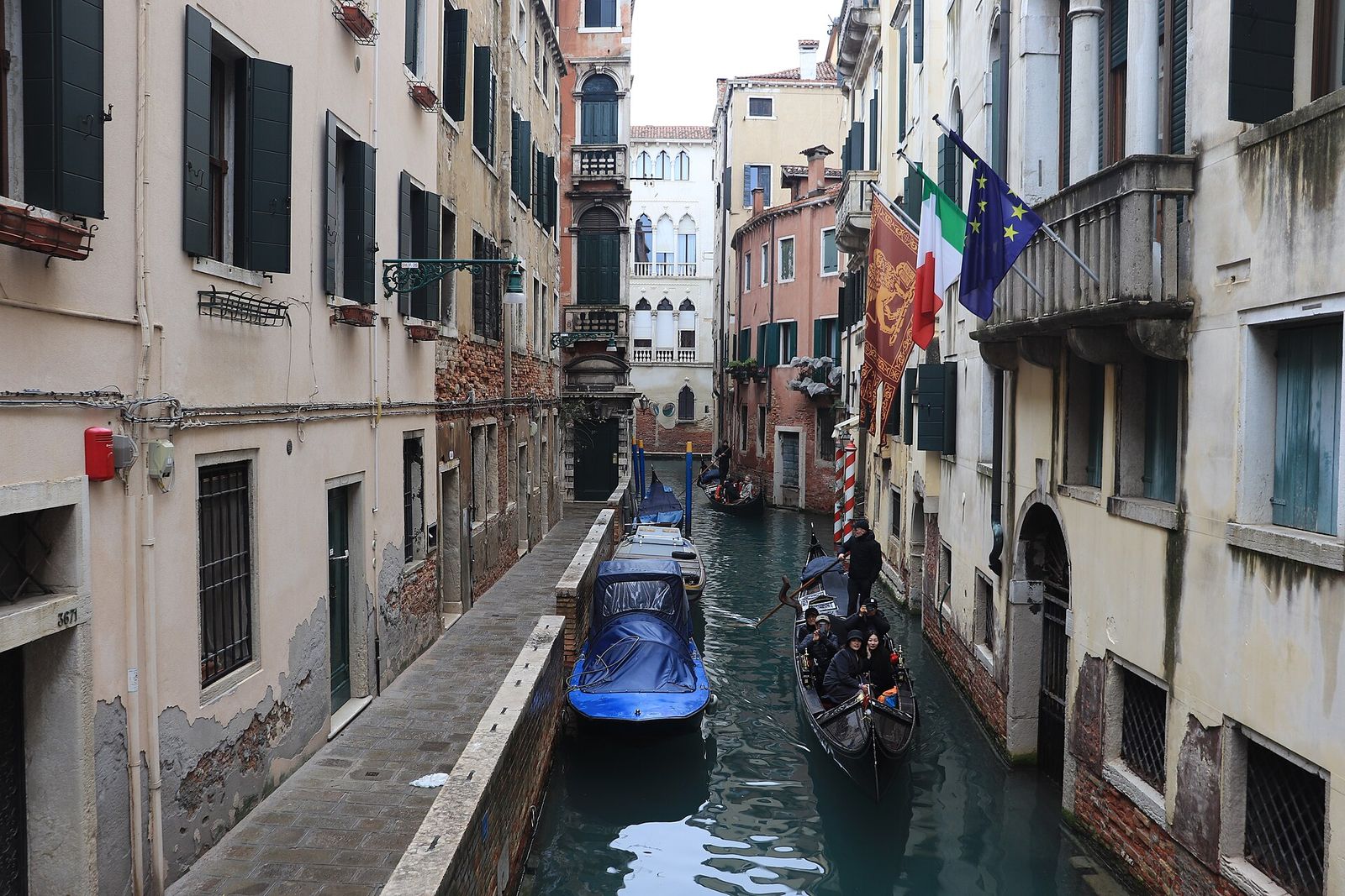 A gondola gliding along the narrow Rio de la Verona between old house walls