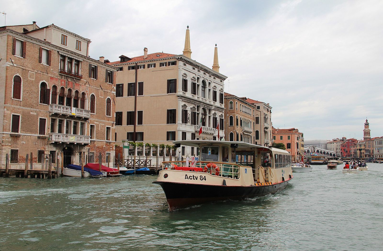 A vaporetto water bus on the Grand Canal, with the Rialto Bridge in the distance